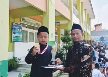 Kepala SD Negeri 18 Campago Guguak Bulek Dasril seahkan reward untuk Dafa peraih Golden Winner lomba science tingkat provinsi Sumatera Barat yang digelar Global House baru-baru ini.
